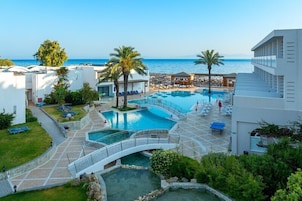 Una piscina al aire libre, sombrillas, sillones reclinables de piscina