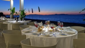 Taula posta per a sopar amb vista al mar al capvespre.