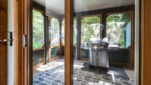 Eine moderne Küche mit Edelstahlgrill, großen Fenstern und einem geometrisch gemusterten Boden.
