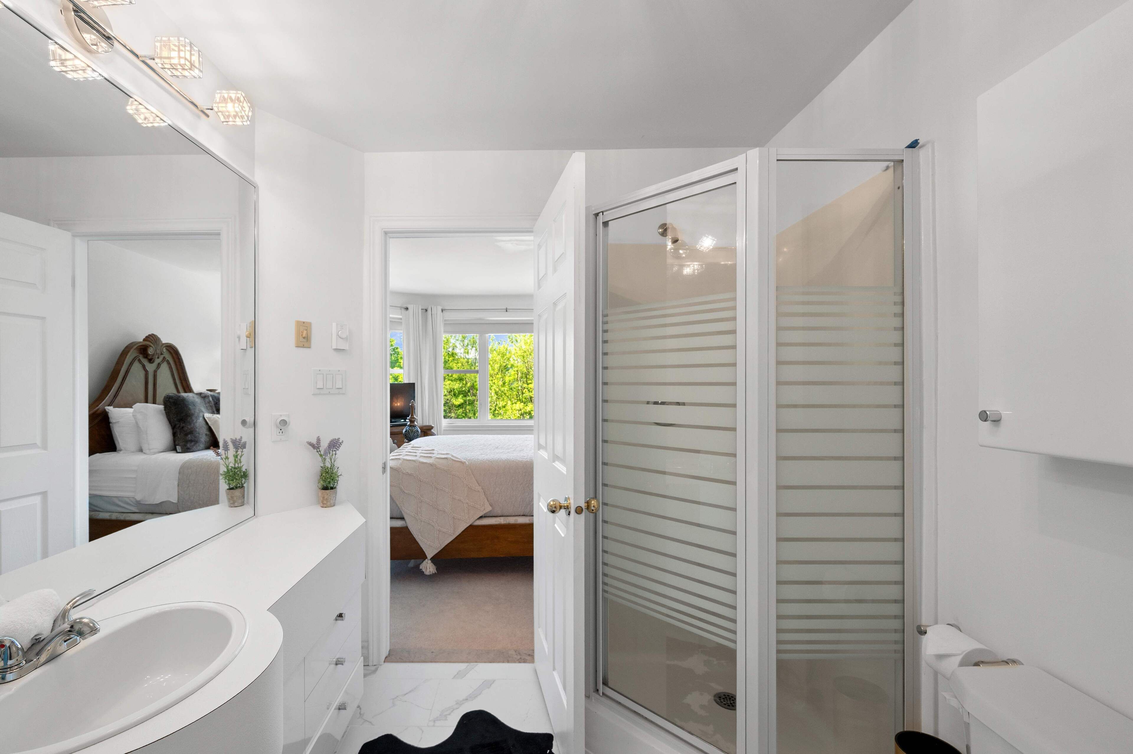 A modern bathroom with a white vanity, a bathtub, and a shower area.