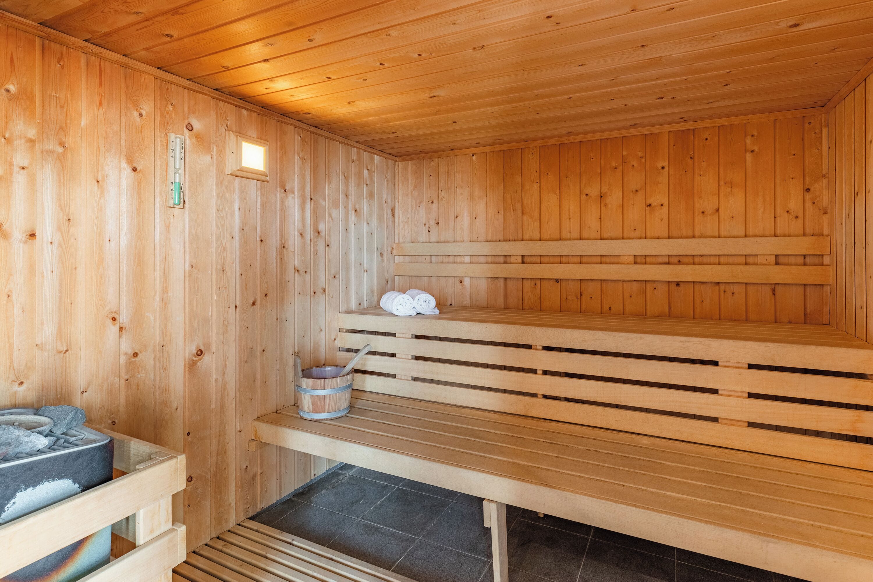 Una sauna de madera con bancos y un asiento integrado.