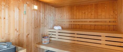 Una sauna de madera con bancos y un asiento integrado.