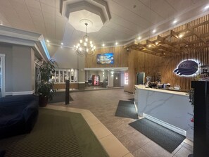 Welcome to our hotel lobby, featuring a spacious reception area with a modern design, a large flat-screen TV, and comfortable seating areas.