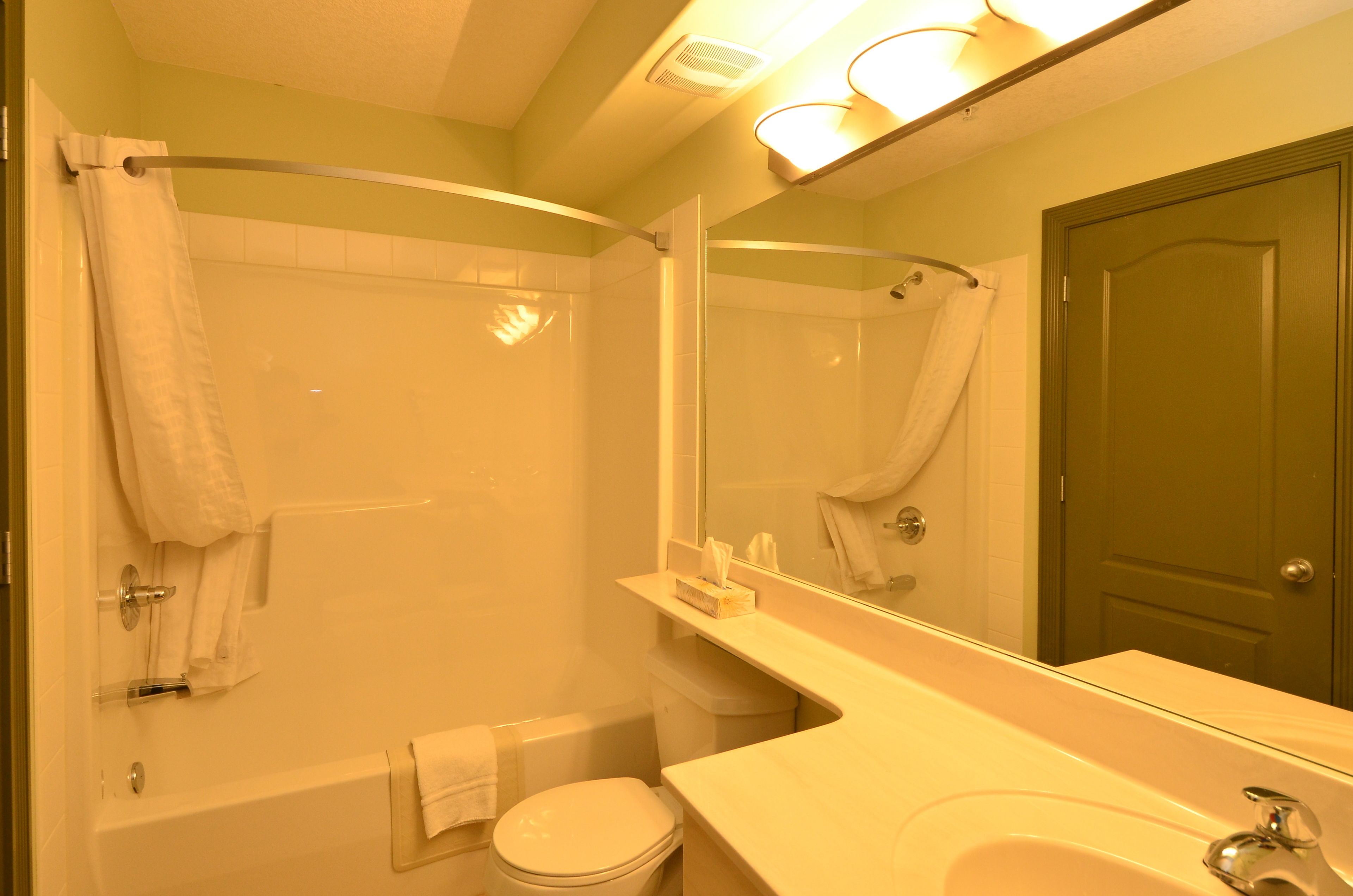 A bathroom with a bathtub, toilet, and sink.