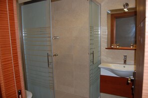Een douche, een haardroger, pantoffels, handdoeken