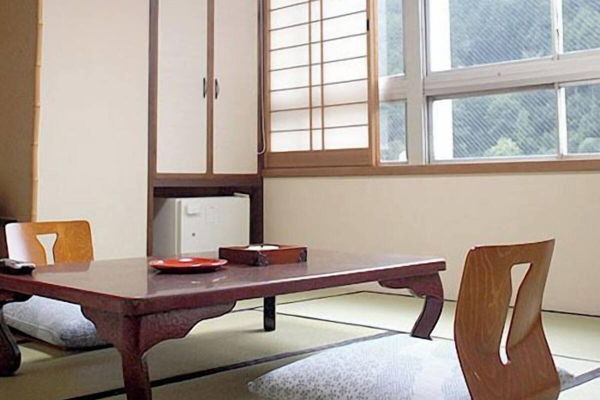 A traditional Japanese-style room with tatami flooring, a low table, and sliding doors.