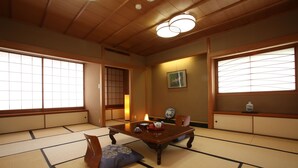 A traditional Japanese room with tatami flooring, a low wooden table, and sliding doors. - Mutsumikan (Gero)