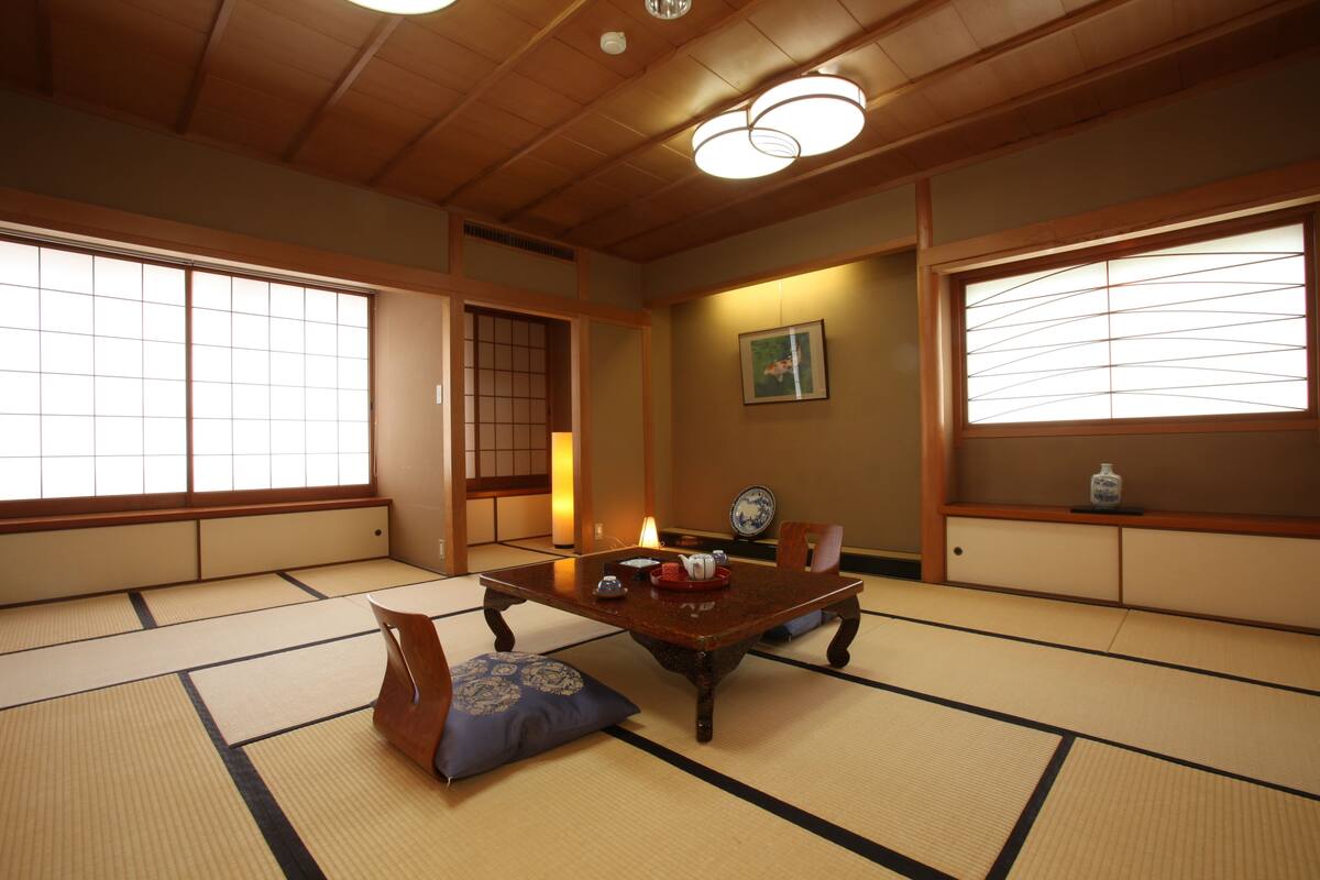 A traditional Japanese room with tatami flooring, a low wooden table, and sliding doors.