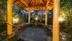 A hot spring area with wooden beams, stone steps, and a wooden gazebo. - Mutsumikan (Gero)