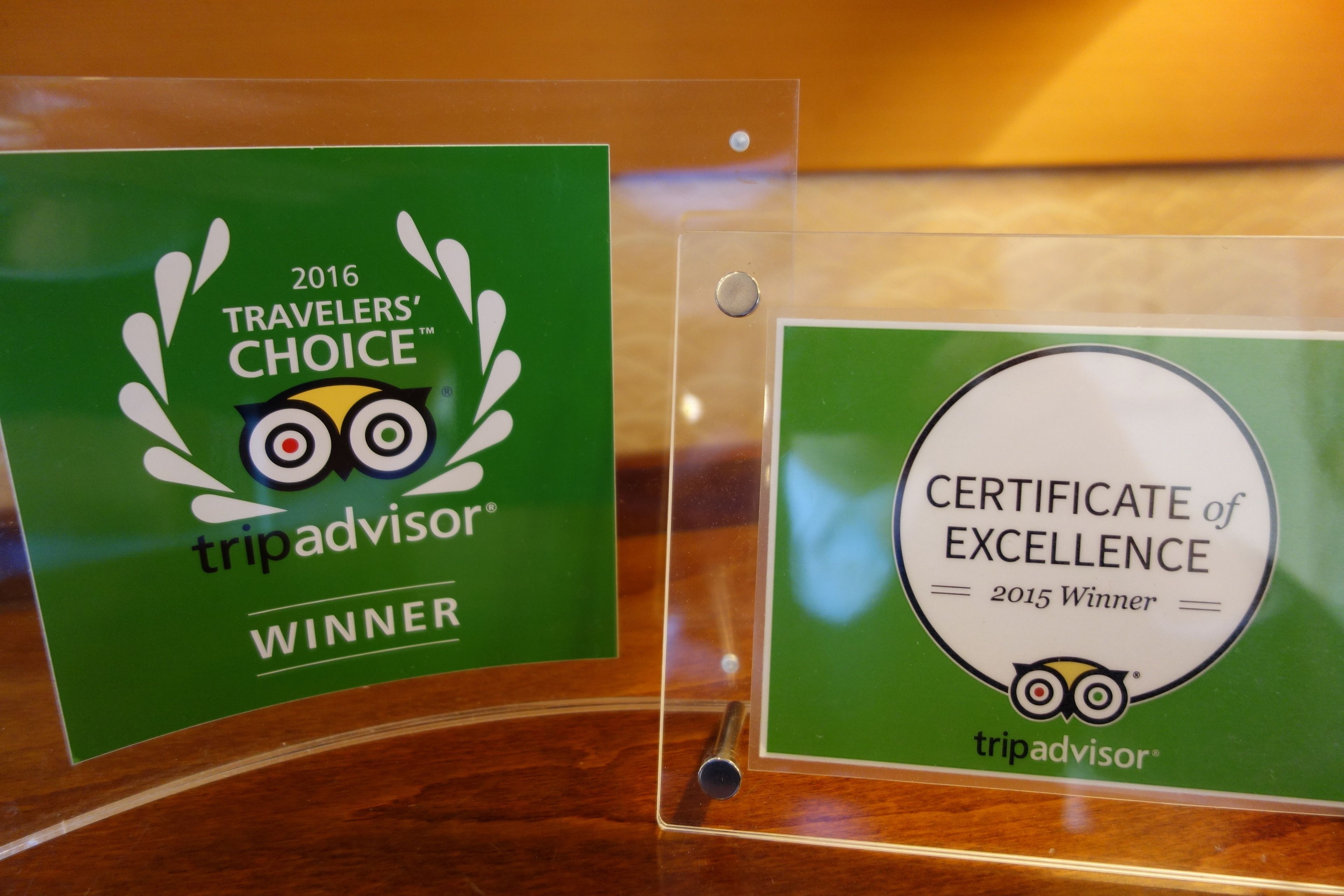 Two award plaques for TripAdvisor, one for 2016 Traveler's Choice Winner and another for 2015 Certificate of Excellence.