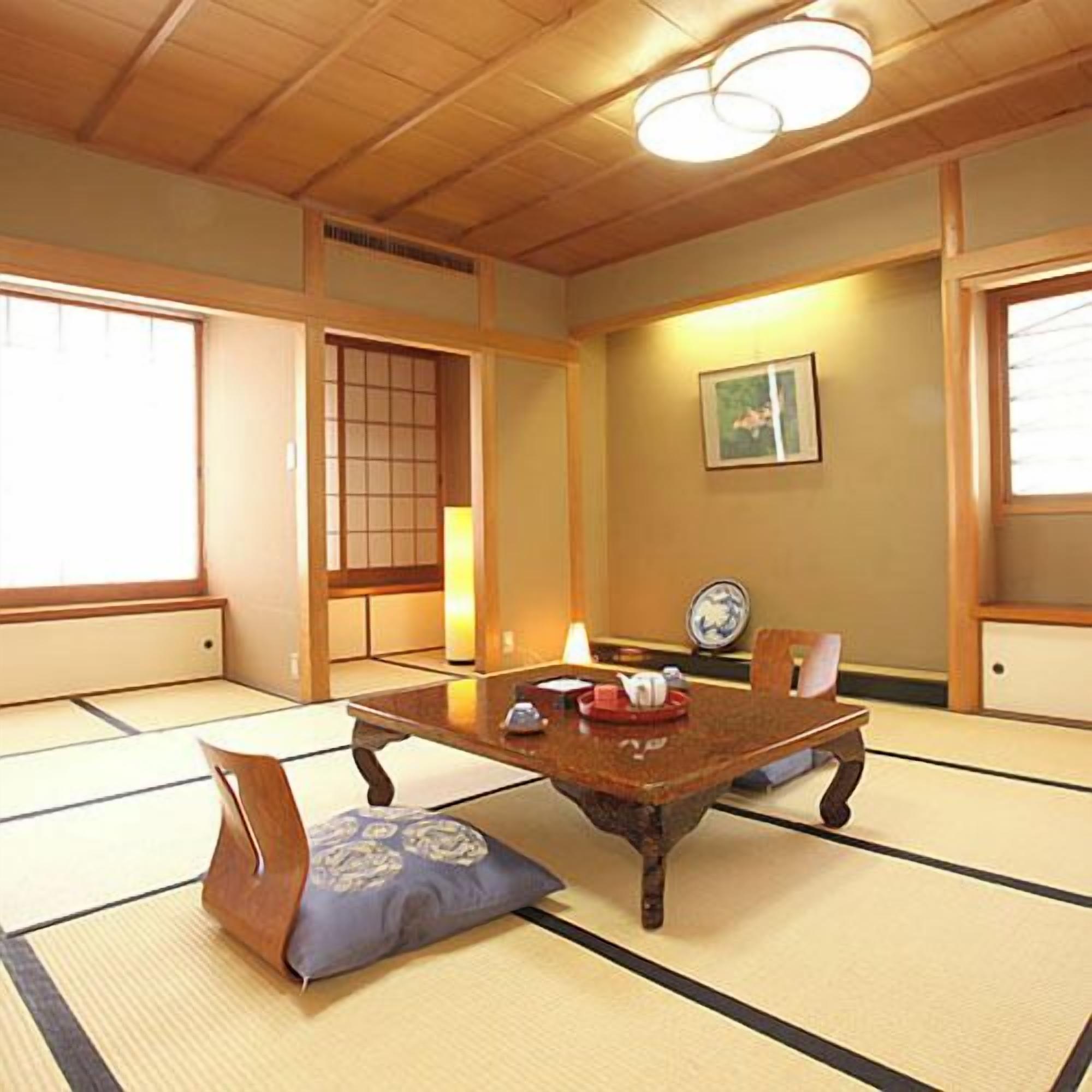 Une pièce de style japonais traditionnel, avec un sol recouvert de tatamis, une petite table en bois et une porte coulissante.