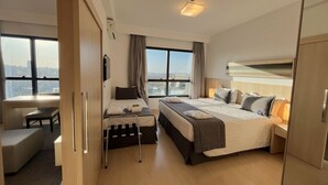 Habitación de hotel moderna con una cama grande, un escritorio y vistas a la ciudad.