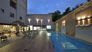 Zona de piscina con sillas de descanso y comedor.