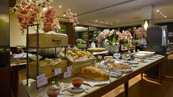 Ein Buffet mit verschiedenen Speisen und dekorativen Blumen.