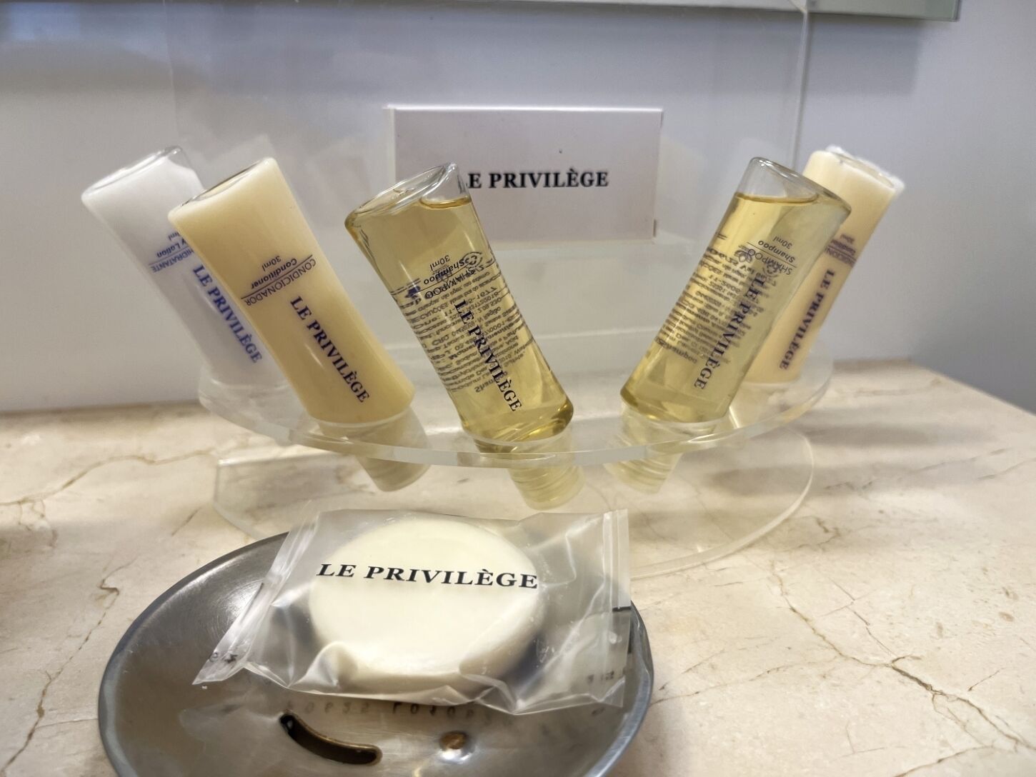 A display of Le Privilege skincare products on a marble countertop.