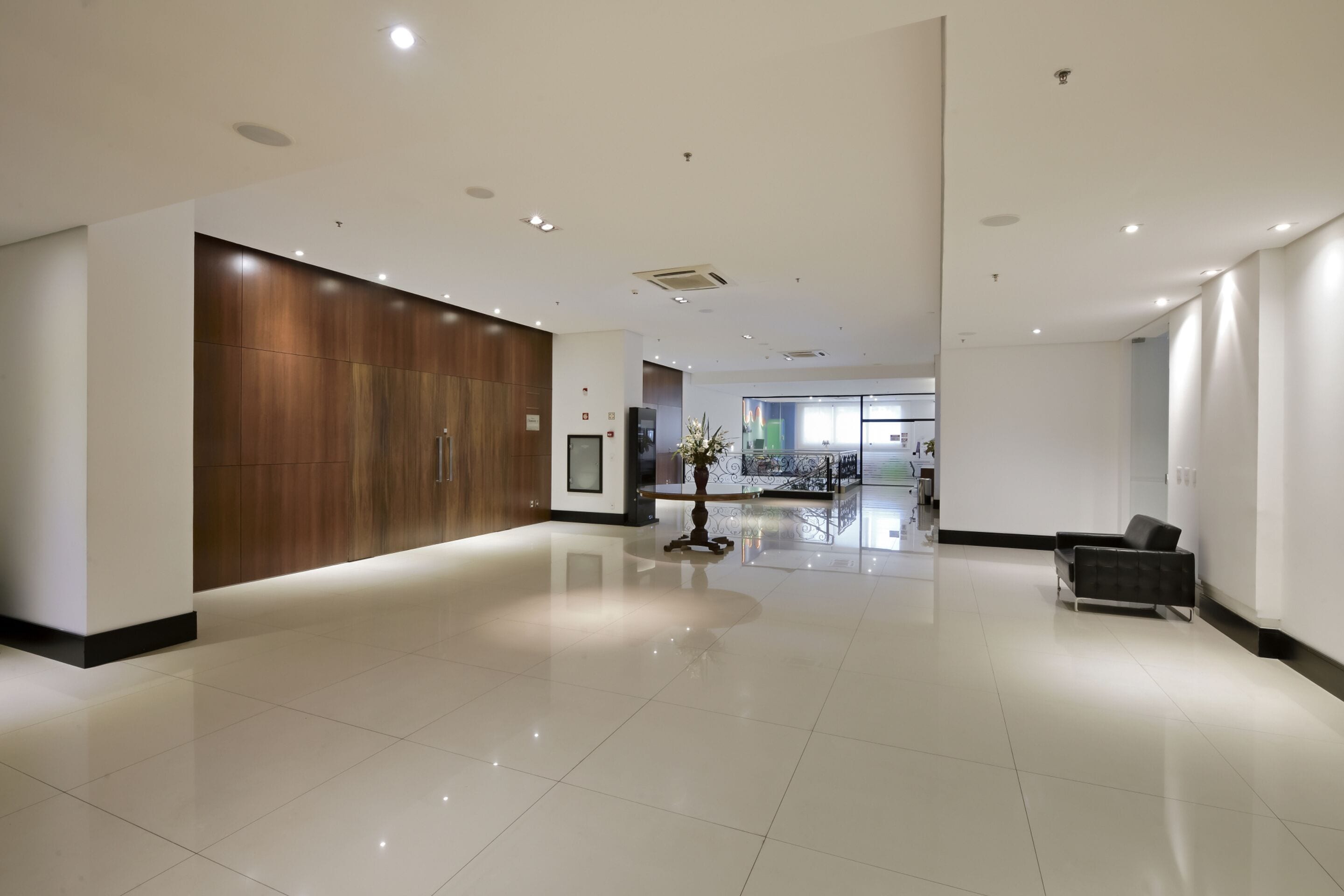 A spacious lobby with a polished floor, a reception desk, and a seating area.