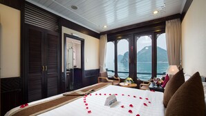 Ein Hotelzimmer mit einem großen Bett, Meerblick und einem Balkon.