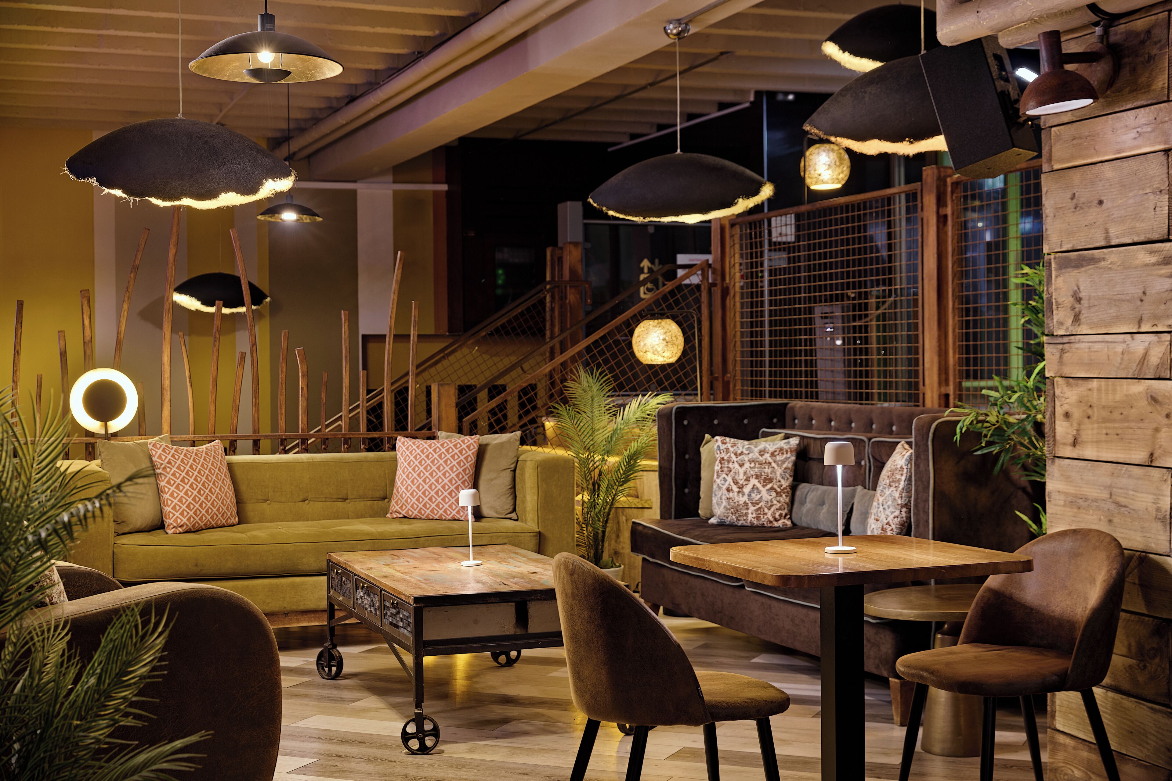 A modern interior with a sofa, dining table, chairs, and pendant lighting.