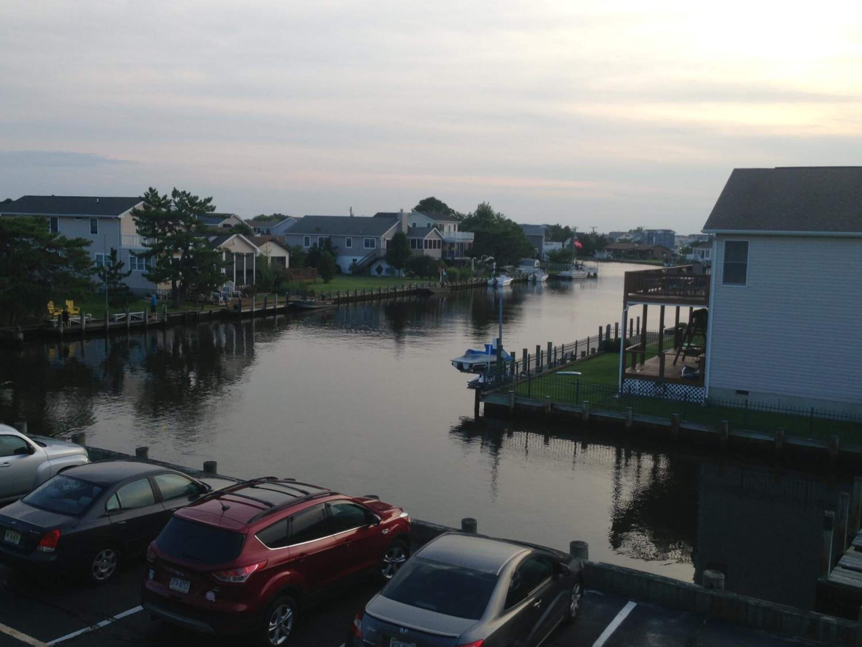 Un port de plaisance avec des bateaux amarrés, une rivière paisible et des maisons qui bordent ses rives.