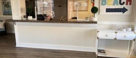 A reception area with a counter, a sign indicating 'BEACH', and a plant.