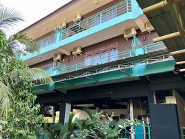 A two-story building with a balcony and air conditioning units.