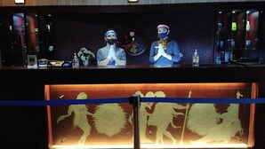 A reception desk with two staff members, a digital screen, and a decorative glass panel below. - Furaya Hotel (Pekanbaru)