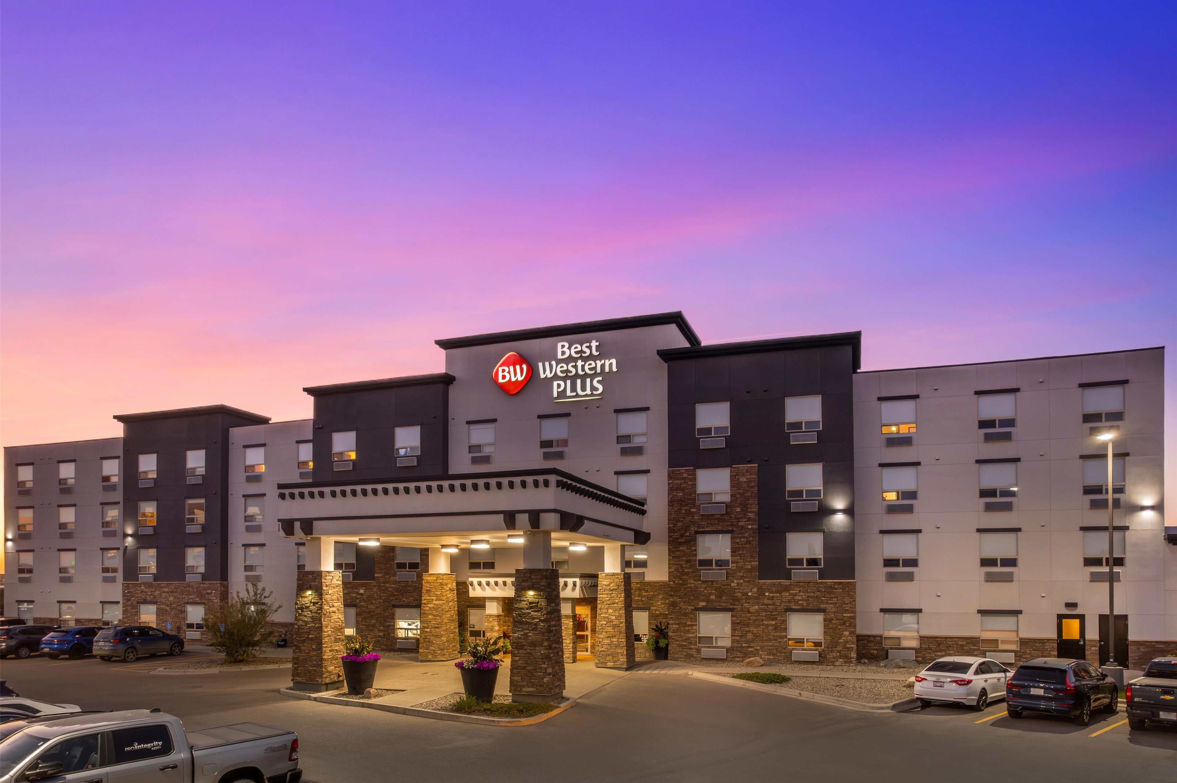 Un hotel Best Western Plus con diseño moderno, que cuenta con una entrada destacada y varios espacios de estacionamiento.