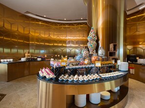 A buffet area with a variety of food items and a decorative Christmas tree. - Novotel Chennai Sipcot (Tirupporur)