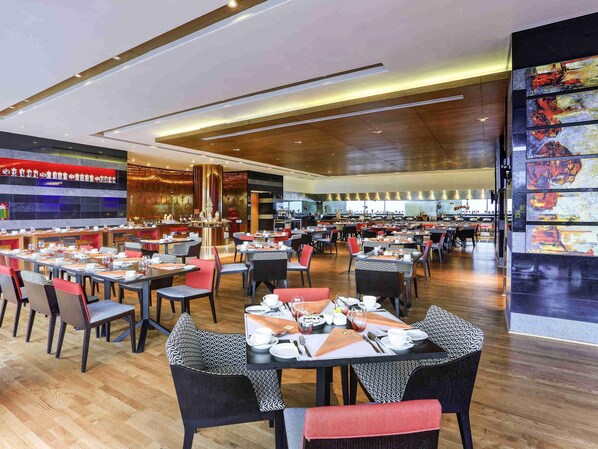 Un restaurante espacioso con varias zonas de comedor, un bar y una cocina visible al fondo.