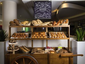 Une vitrine de boulangerie présentant diverses pâtisseries et une enseigne au-dessus.