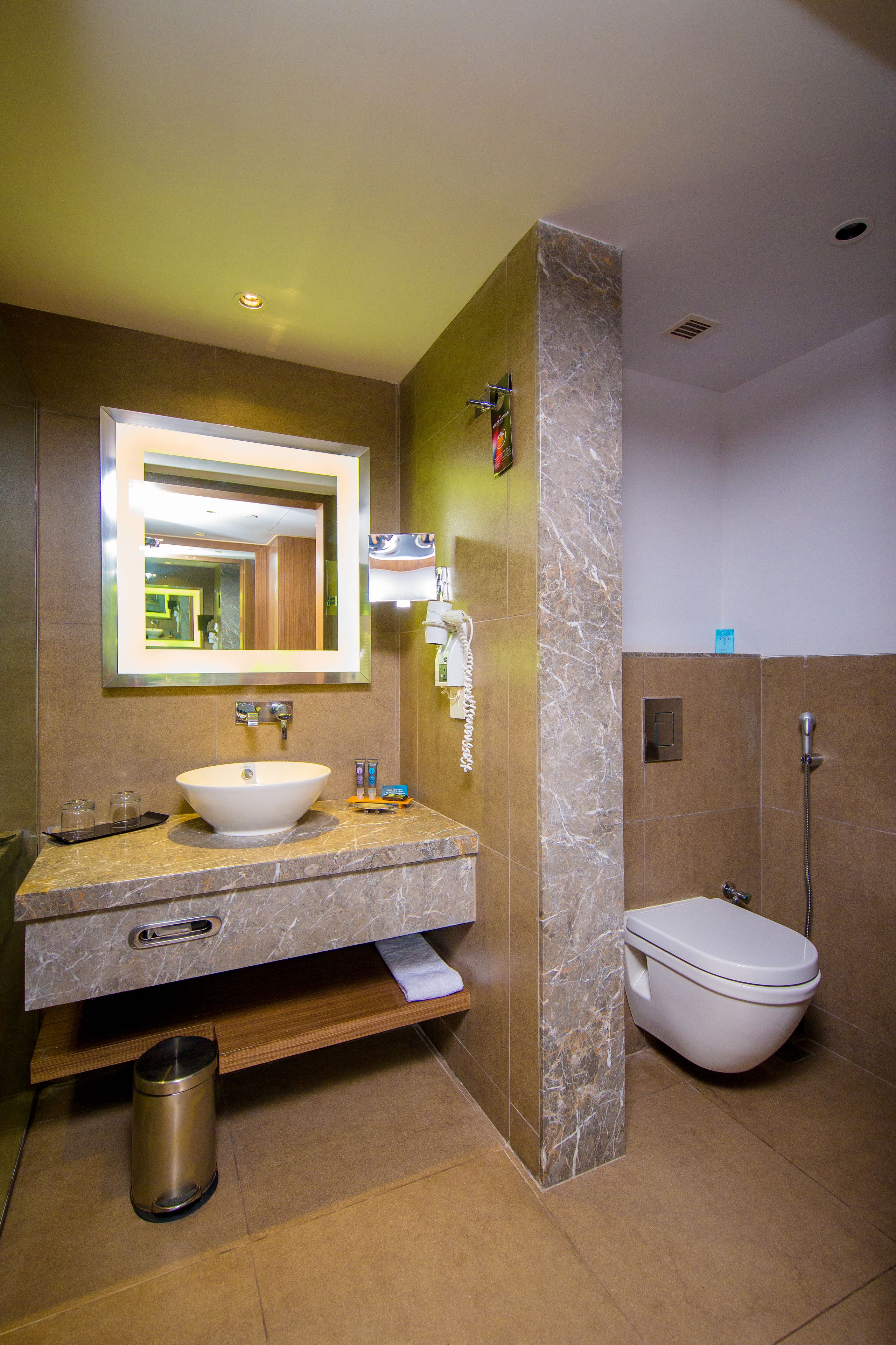A modern bathroom with a large sink, mirror, and shower.