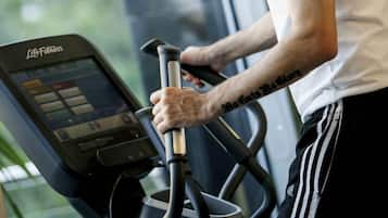 Una persona usando una máquina elíptica Life Fitness en un gimnasio con una ventana al fondo.