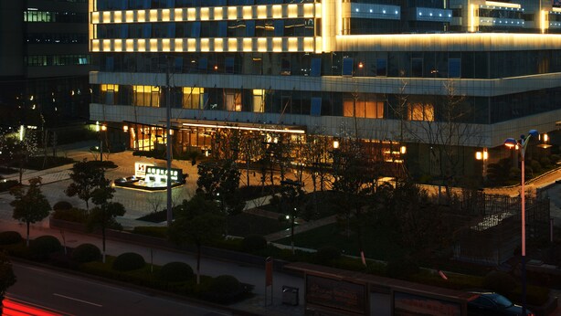 A modern hotel building with a prominent sign reading "SWISS-BELHOTEL".