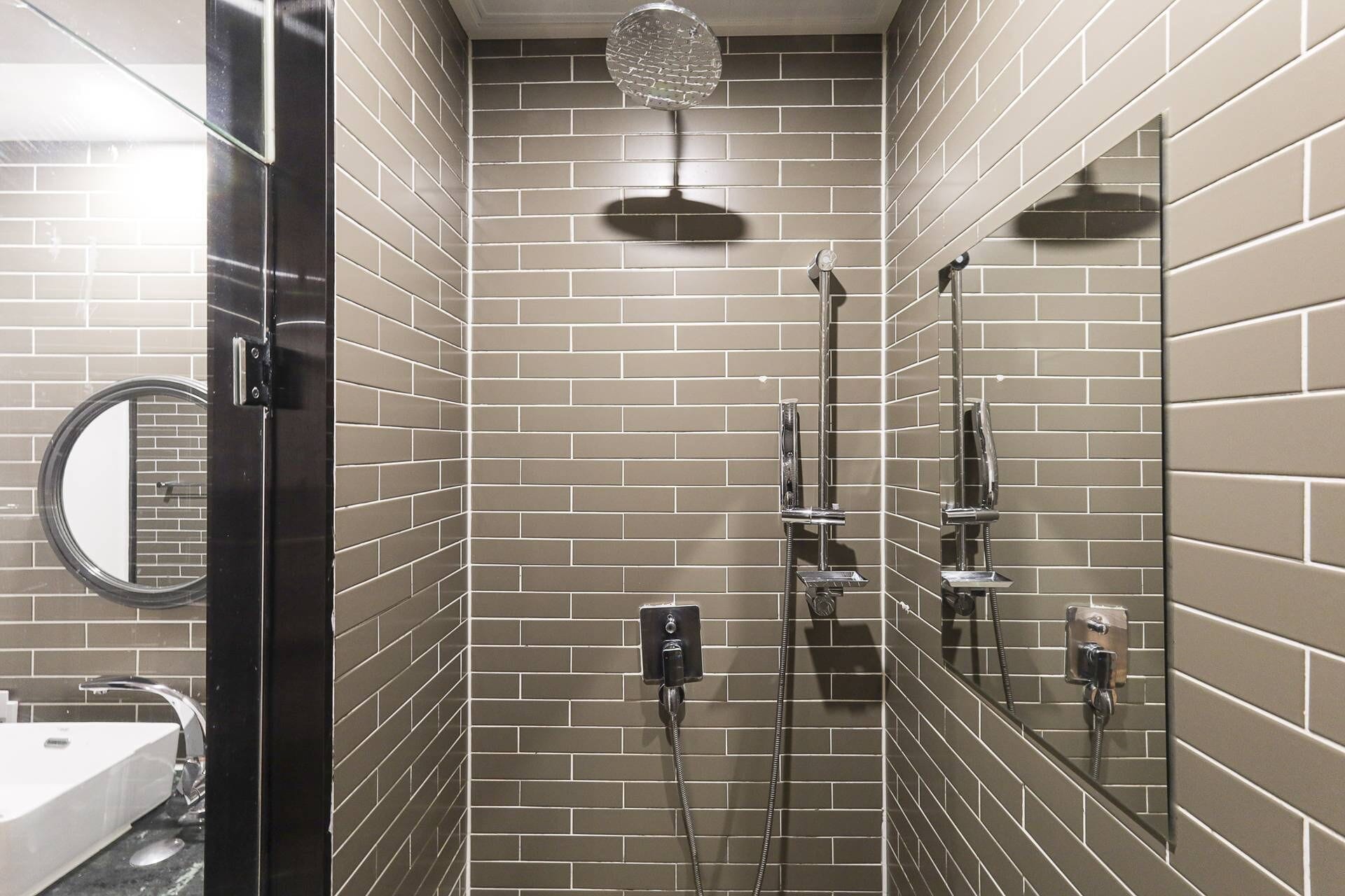 A bathroom with a shower, a sink, and a mirror.