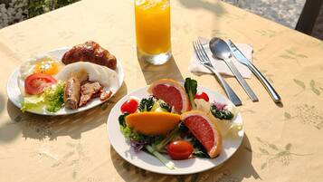 A table with two plates of food, a glass of orange juice, and cutlery.