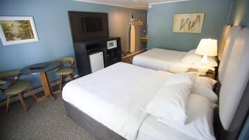 A hotel room with two beds, a desk, a chair, a TV, and a microwave.