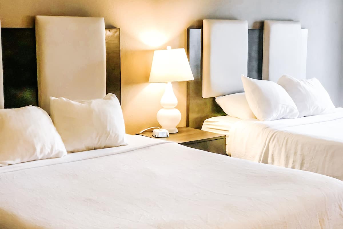 deluxe room, 2 queen beds | premium bedding, desk, iron/ironing board, free cots/infant beds