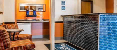 Un vestíbulo de hotel con una recepción, una zona de estar y un mostrador de check-in.