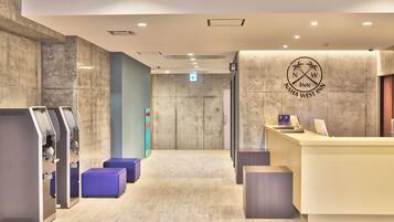 A reception area with a counter, a logo, and a direction sign.