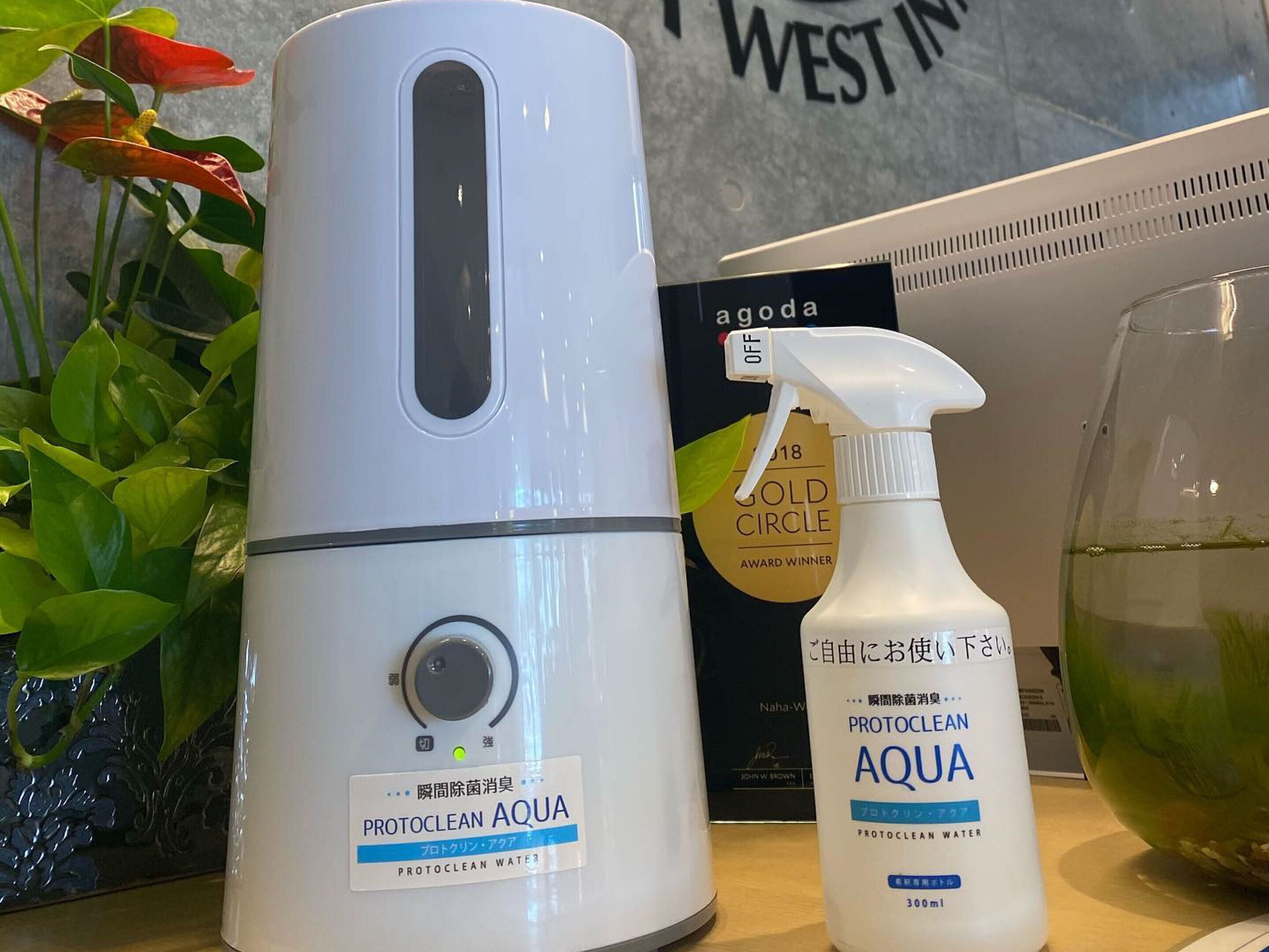 A water purifier, a bottle of Aqua, and a Gold Circle award on a table.
