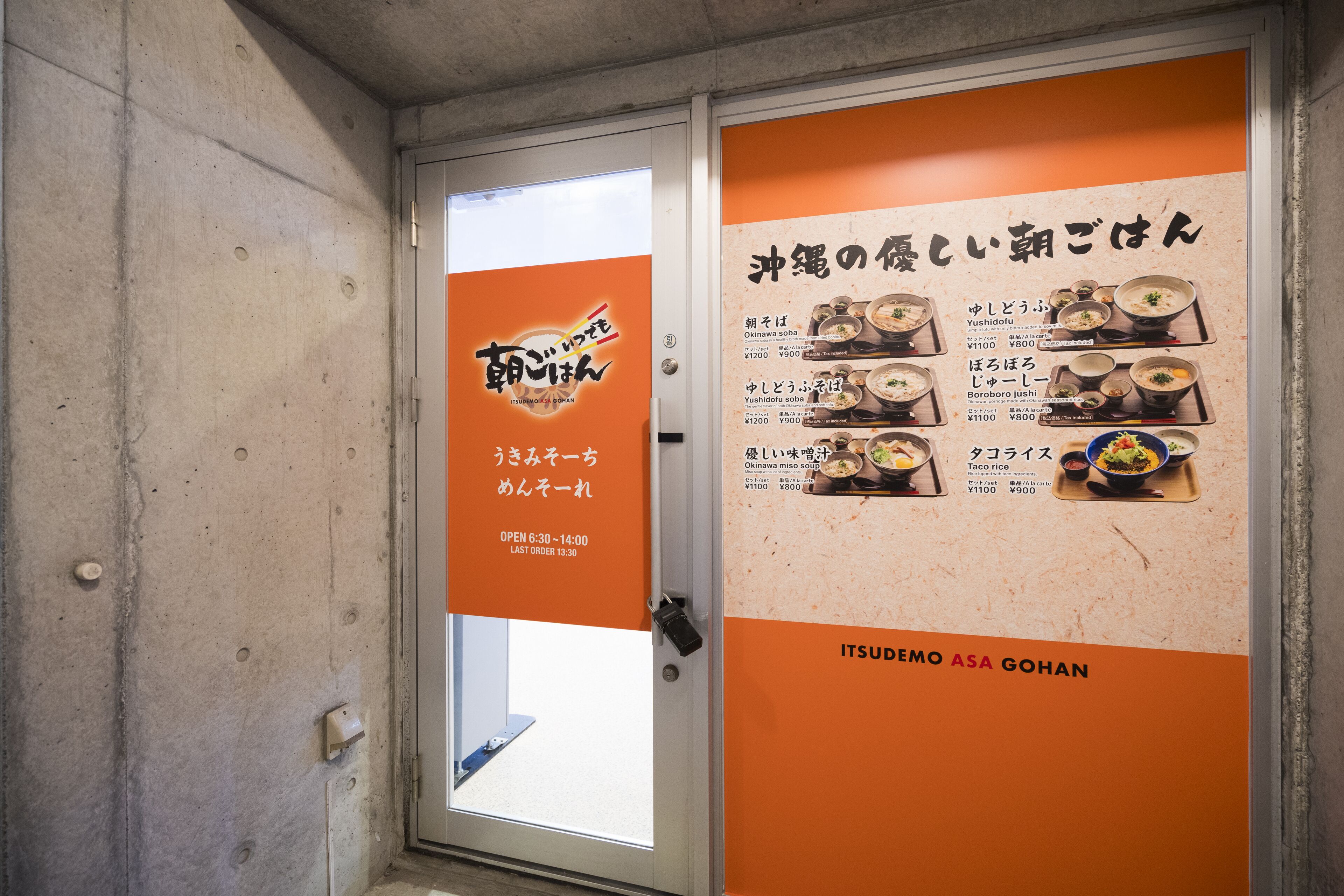 L'intérieur d'un restaurant, avec un panneau affichant le menu et les prix des différents plats.