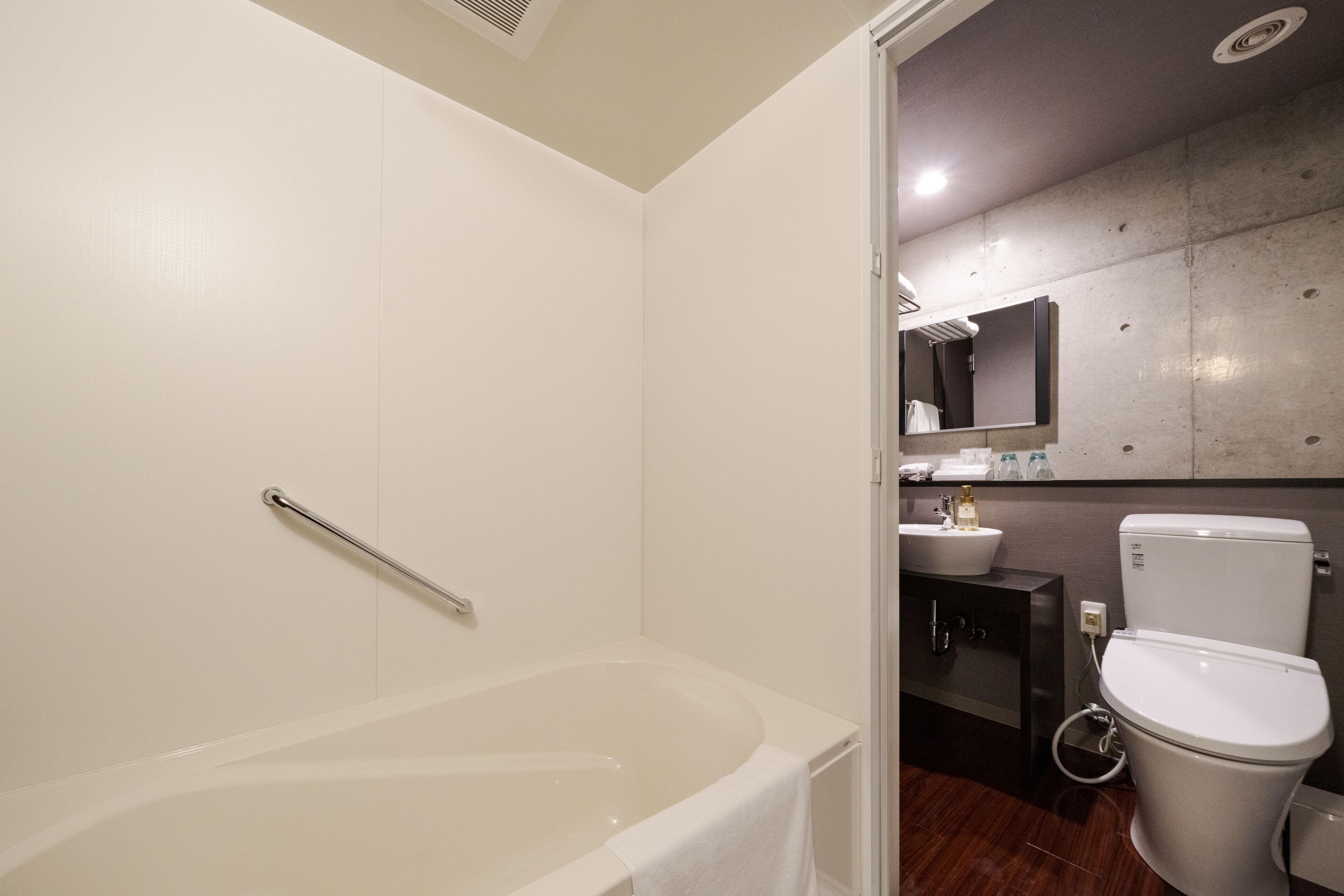 A modern bathroom with a bathtub, toilet, and sink.