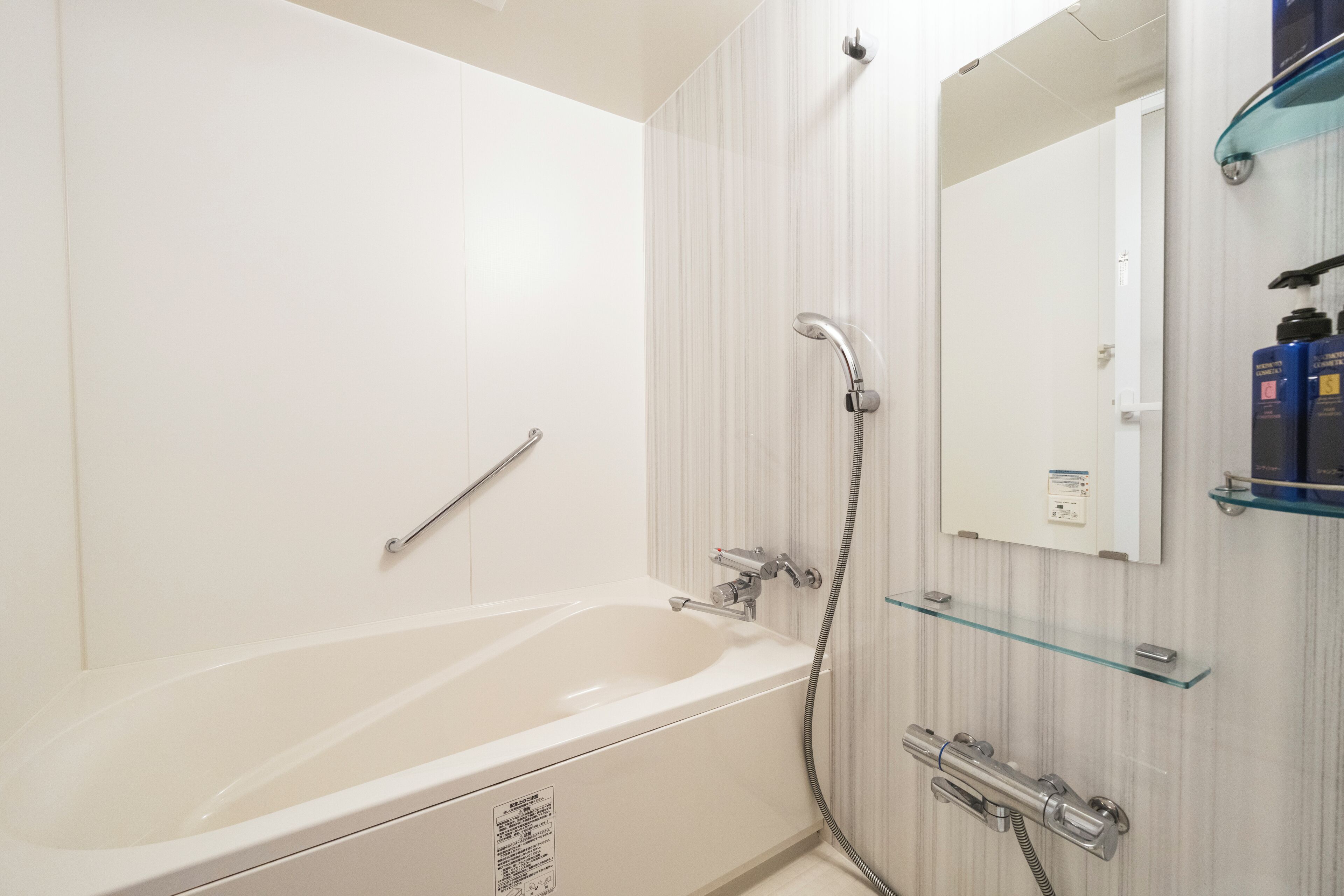 A modern bathroom with a bathtub, a glass shower enclosure, and a mirror.