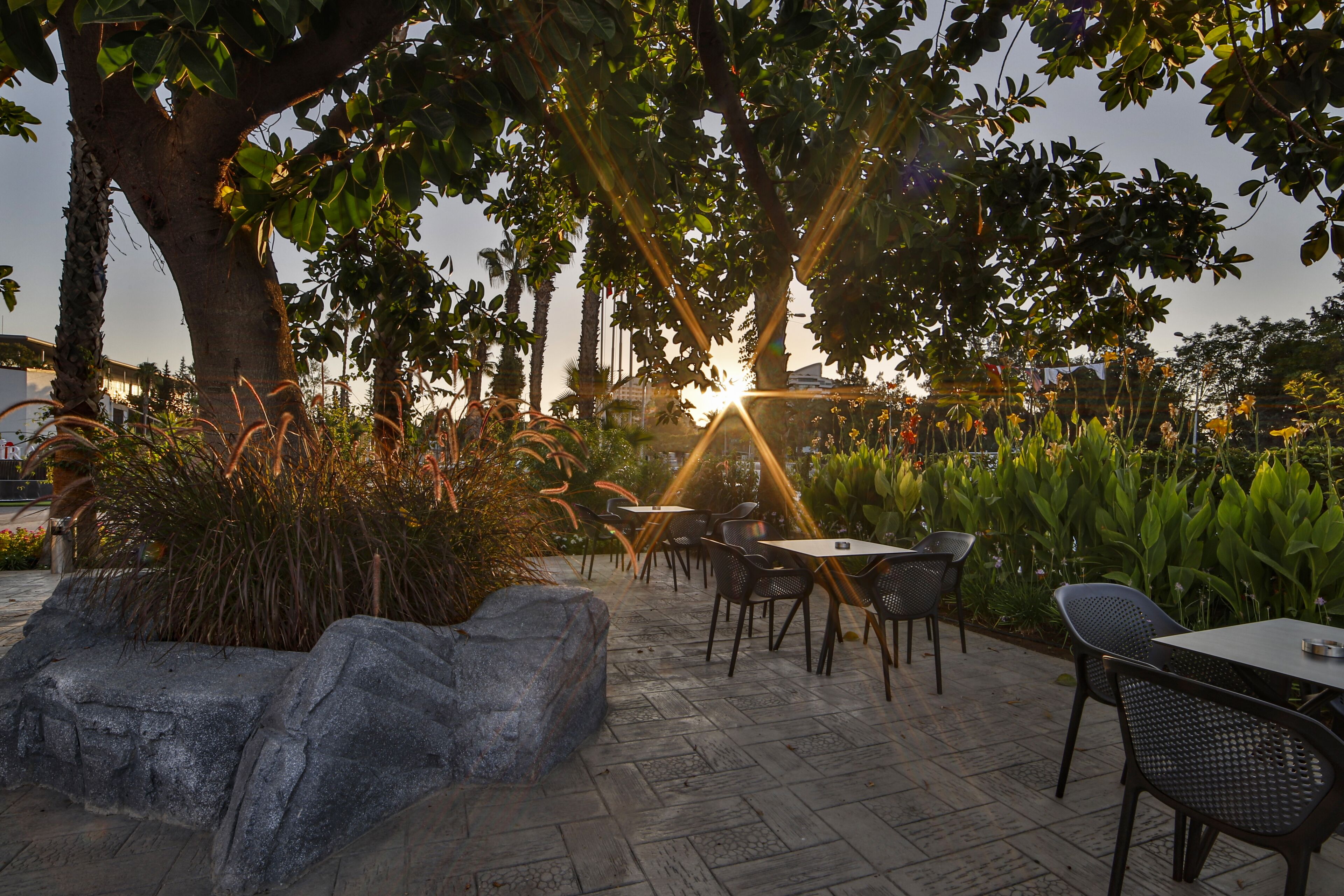 An outdoor patio area with stone flooring, metal chairs, and tables.