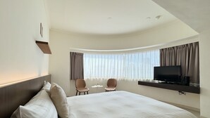 A hotel room with a large bed, two chairs, a TV, and a small table. - Finders Hotel Hualien Da-Tong (Hualien City)
