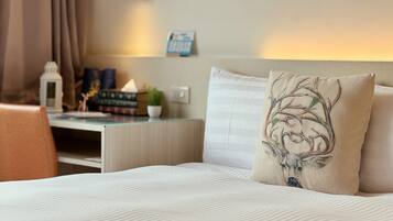 A neatly arranged hotel room with a bed, a desk, and a chair.