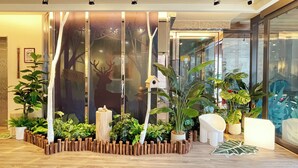 A modern interior with a wooden fence, potted plants, and a glass partition with a deer silhouette. - Finders Hotel Hualien Da-Tong (Hualien City)