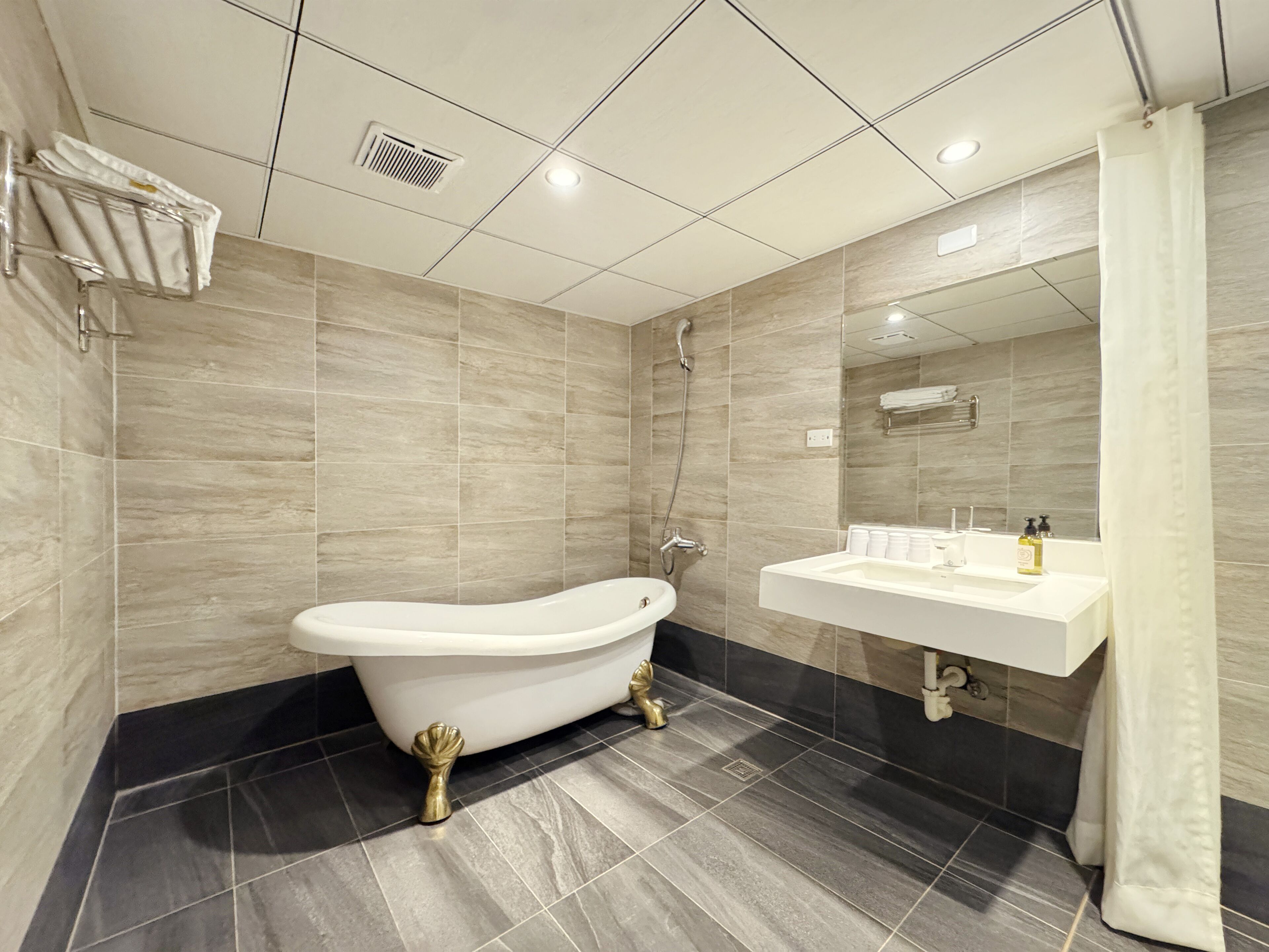 A modern bathroom with a freestanding bathtub, a vanity with a mirror, and a shower.
