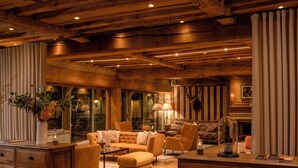 A cozy, well-lit living room with wooden beams, comfortable seating, and a fireplace. - Les Manoirs de Tourgéville (Tourgeville)