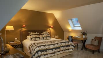 Une chambre à coucher avec un grand lit, deux tables de chevet, un bureau, une chaise et une lucarne.